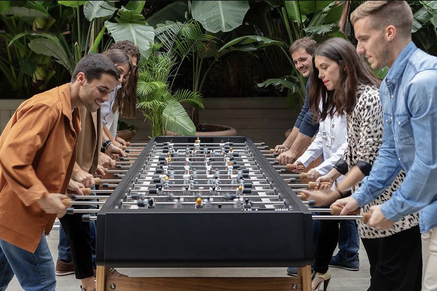 Friends playing on an RS Barcelona foosball table
